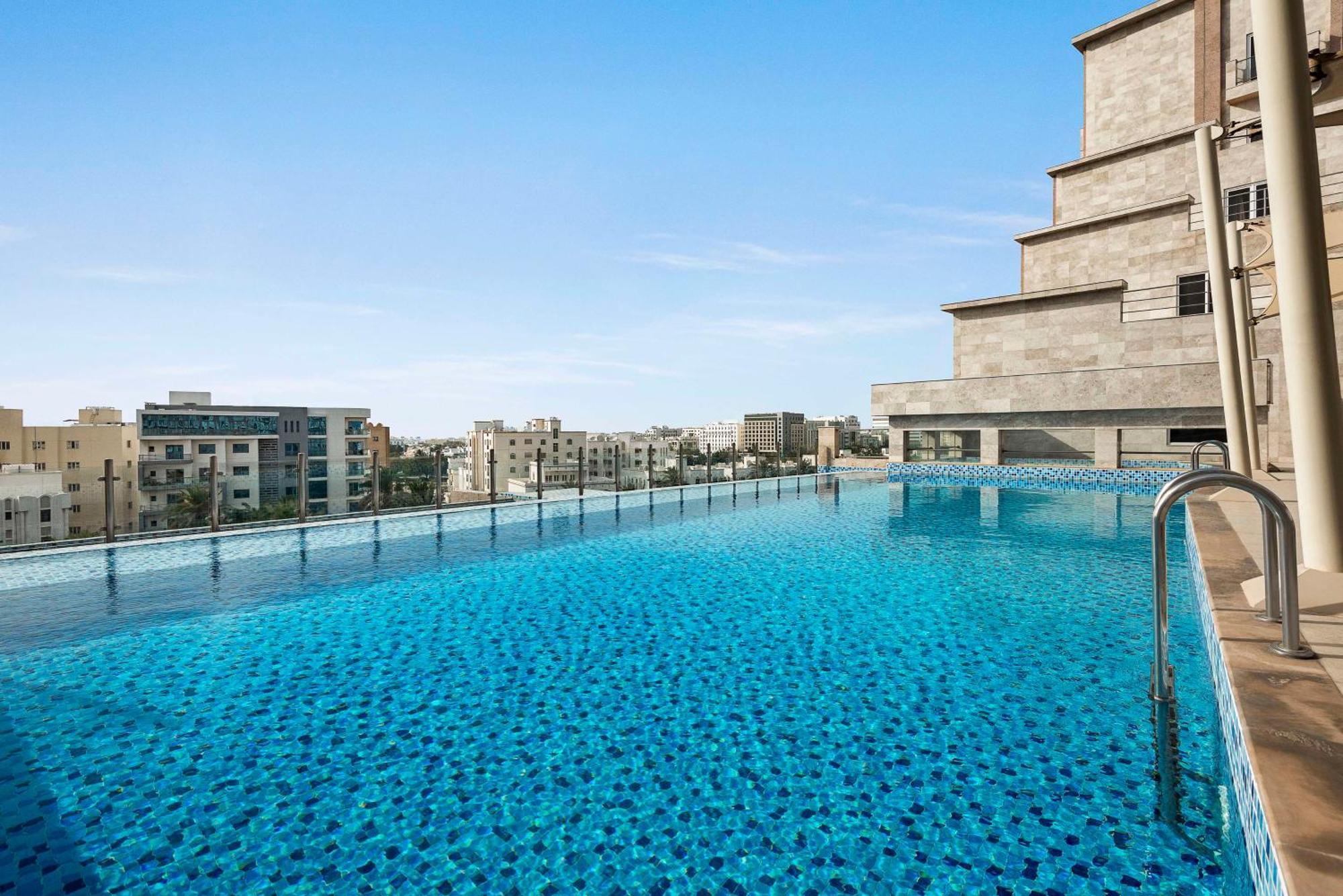 Levatio Suites Mascate Esterno foto The swimming pool at the hotel